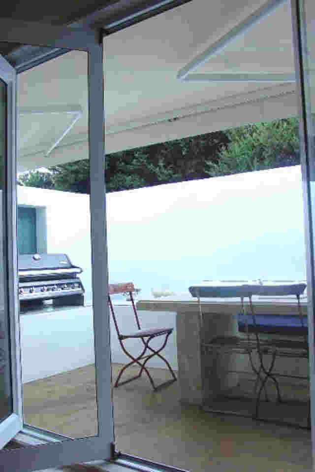 Retractable Awnings - Folding Arm awning in white over private patio area in Waiheke Island copy.jpg