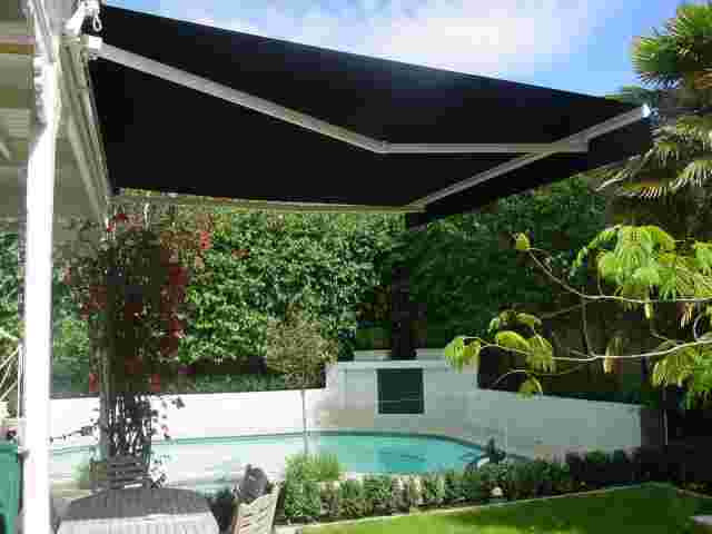 Retractable Awnings - Folding Arm awning in black canvas over pool patio in Freemans Bay copy.JPG